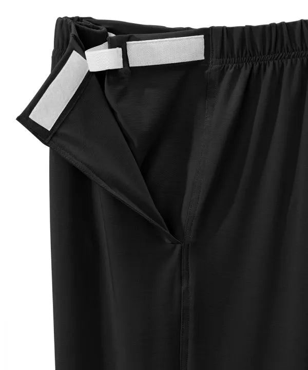 Women’s black pants with side closure, adjustable straps, and loop fasteners on waistband. close-up of side closure